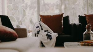 Sofá com manta e almofadas, simbolizando o descanso forçado de um freelancer doente em casa.